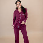 Model looking forward, smiling and wearing the Women's Long Sleeve Pajama Set in Burgundy