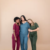 Models standing next to each other while wearing Women's V Necks in Burgundy, Atlantic and Fir and matching Lounge Pants