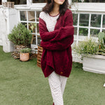 Model wearing the  Women's RIbbed Henley Set in Burgundy Stripe and Cable Knit Cardigan in Burgundy while holding arms across her body