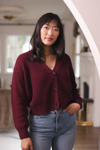 Woman with her hand in her jean pocket wearing cropped cardigan in burgundy