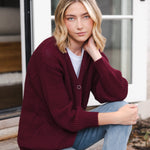 Modal sitting outdoors wearing Chunky Knit Women's Waffle Cardigan in Burgundy over white t-shirt and blue jeans
::: Model is 5'10" wearing size XS ///