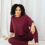 Female sitting on the floor wearing the Bamboo Flex Women’s Leggings in Burgundy with matching short sleeve tee