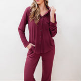 Woman wearing a burgundy pajama set against a white background