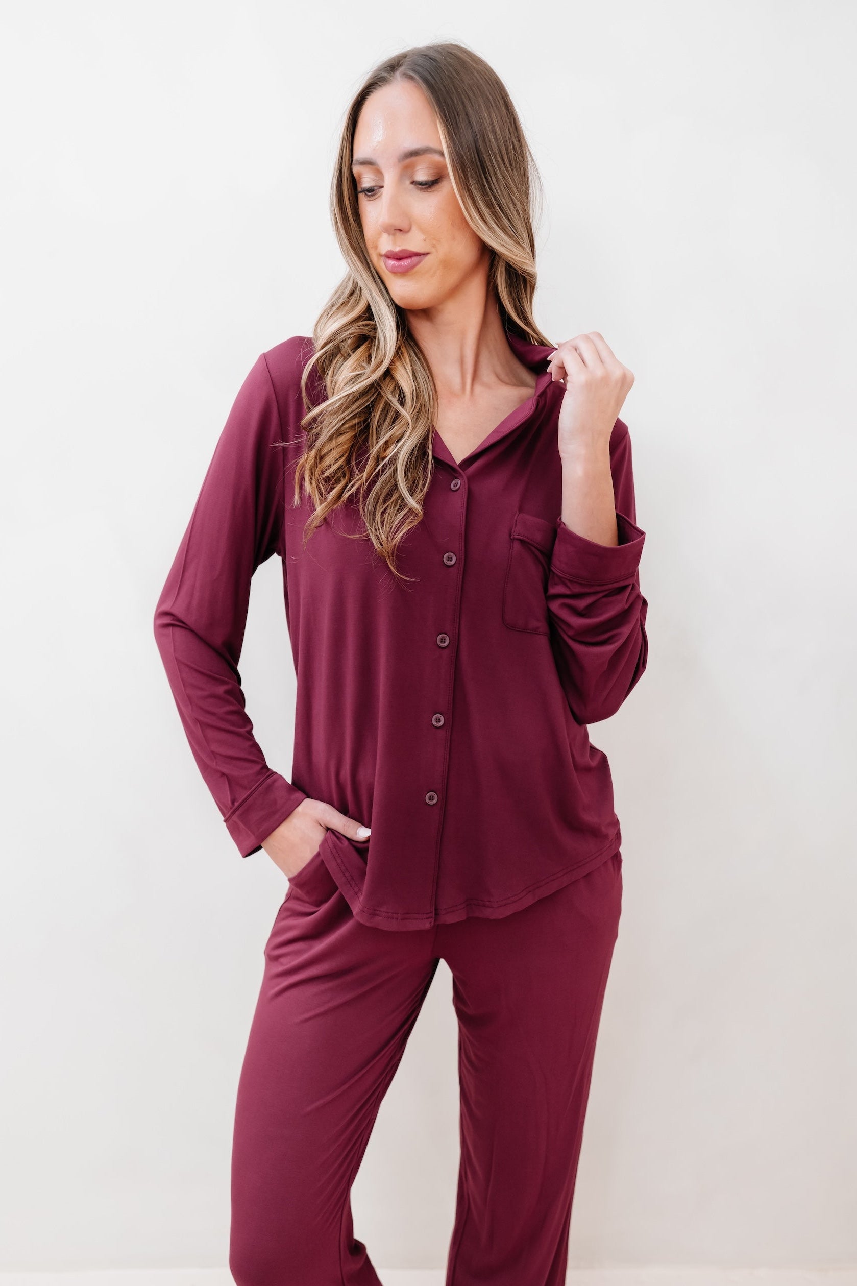 Woman wearing a burgundy pajama set against a white background