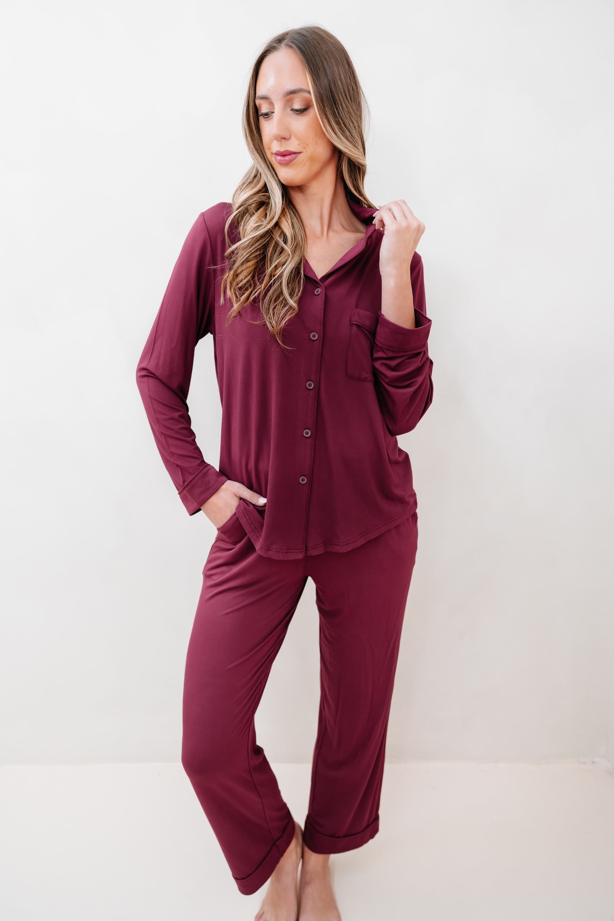 Woman wearing a burgundy pajama set against a white background