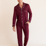 Model wearing Men's Long Sleeve Pajama Set in Burgundy with pockets on a beige background