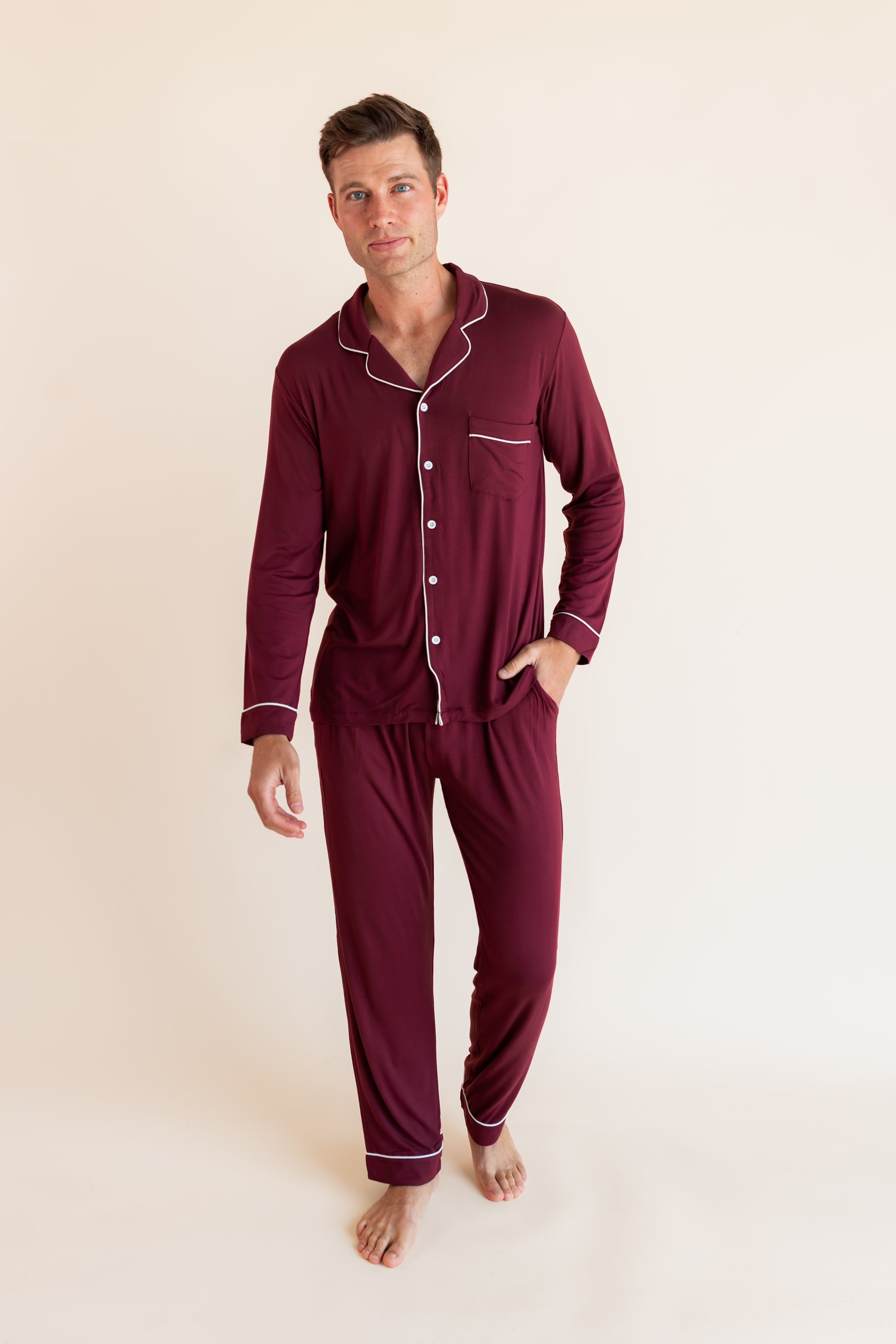 Model wearing Men's Long Sleeve Pajama Set in Burgundy with pockets on a beige background