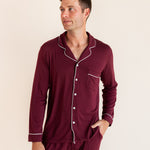 Model wearing Men's Long Sleeve Pajama Set in Burgundy with pockets on a beige background