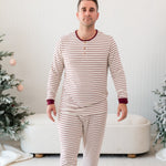 Male walking wearing the Men's Ribbed Henley Set in Burgundy Stripe in front of a Christmas themed backdrop