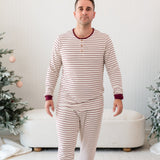Male walking wearing the Men's Ribbed Henley Set in Burgundy Stripe in front of a Christmas themed backdrop