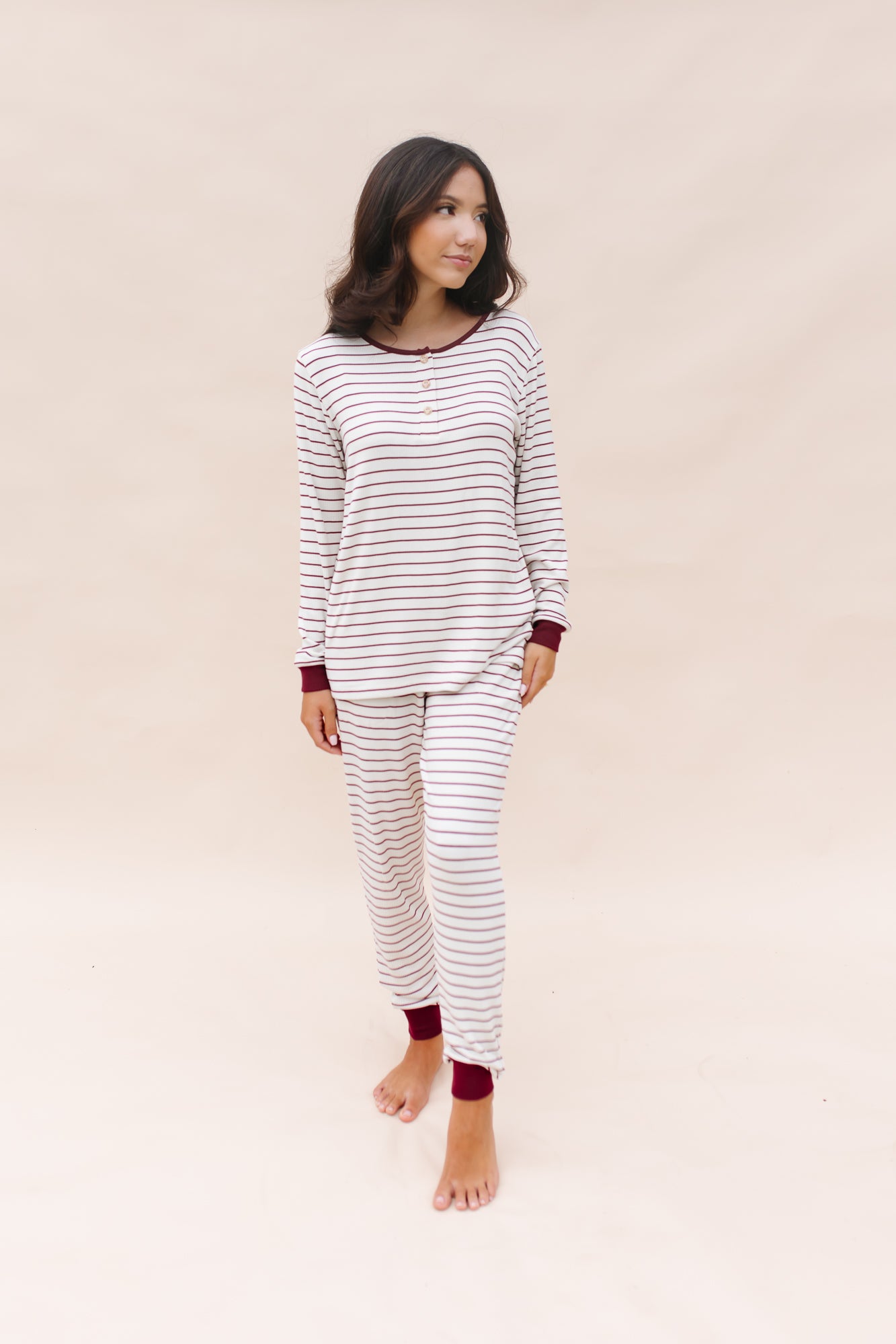 Model looking to the side while wearing the Women's RIbbed Henley Set in Burgundy Stripe