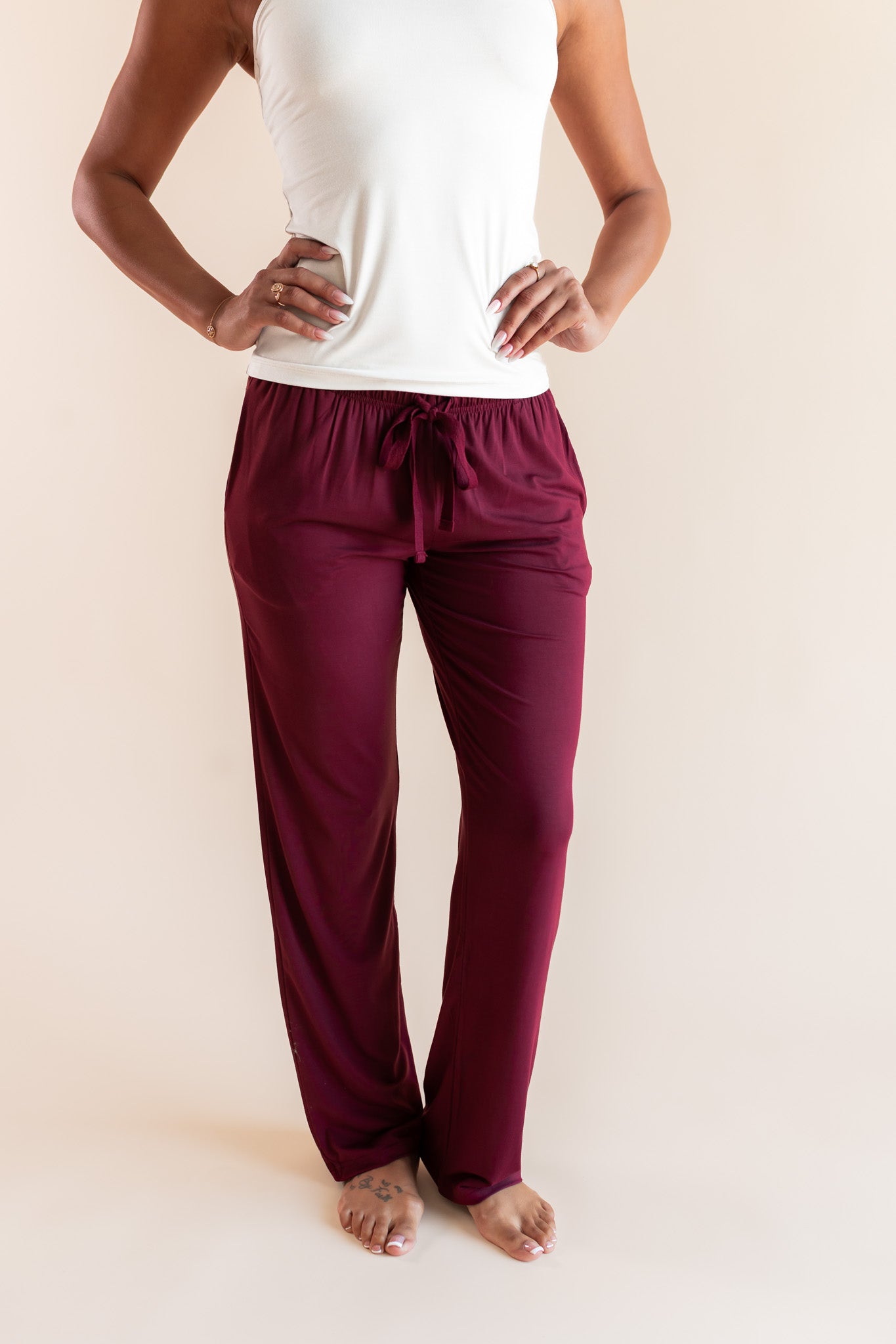 Modal wearing Women's Lounge Pants in Burgundy under white camisole on a beige background
::: Model is 5'9"" wearing size S ///
