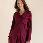 A woman modeling a long-sleeve button-front shirt dress in deep burgundy against a plain beige studio background.
::: Model is 5'9.5" wearing size XS ///