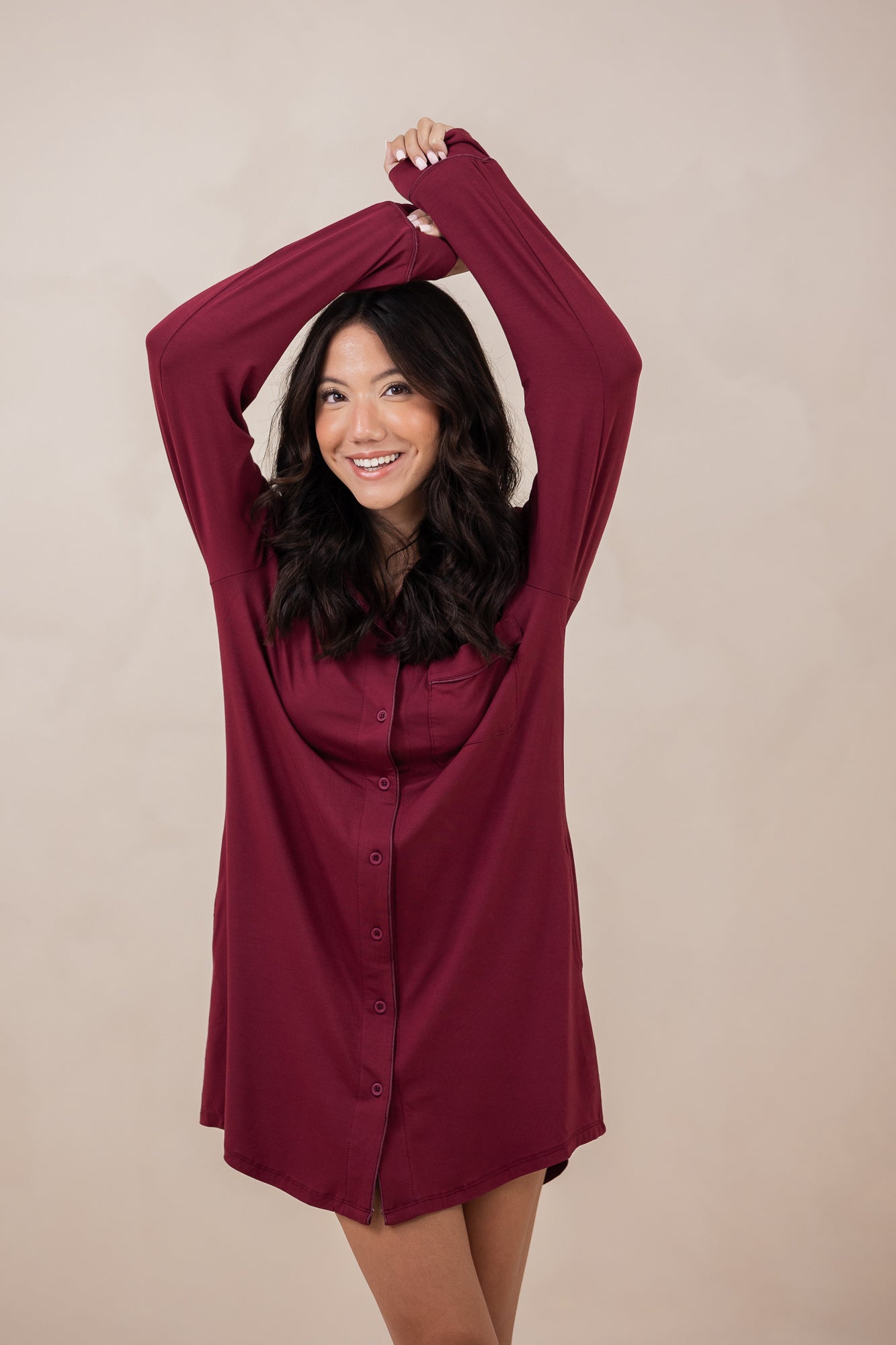 Woman with arms over her head while modeling the Women's Sleep Shirt in Burgundy