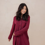 Woman modeling the Kyte Women's Sleep Shirt in Burgundy with arm crossed across her waist