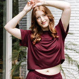 Woman with hands on her head while modeling the Women's Short Sleeve Tee in Burgundy