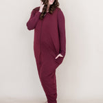 Smiling woman looking to the side while modeling the Kyte Adult Sleep Bag Walker in Burgundy with matching top beneath it