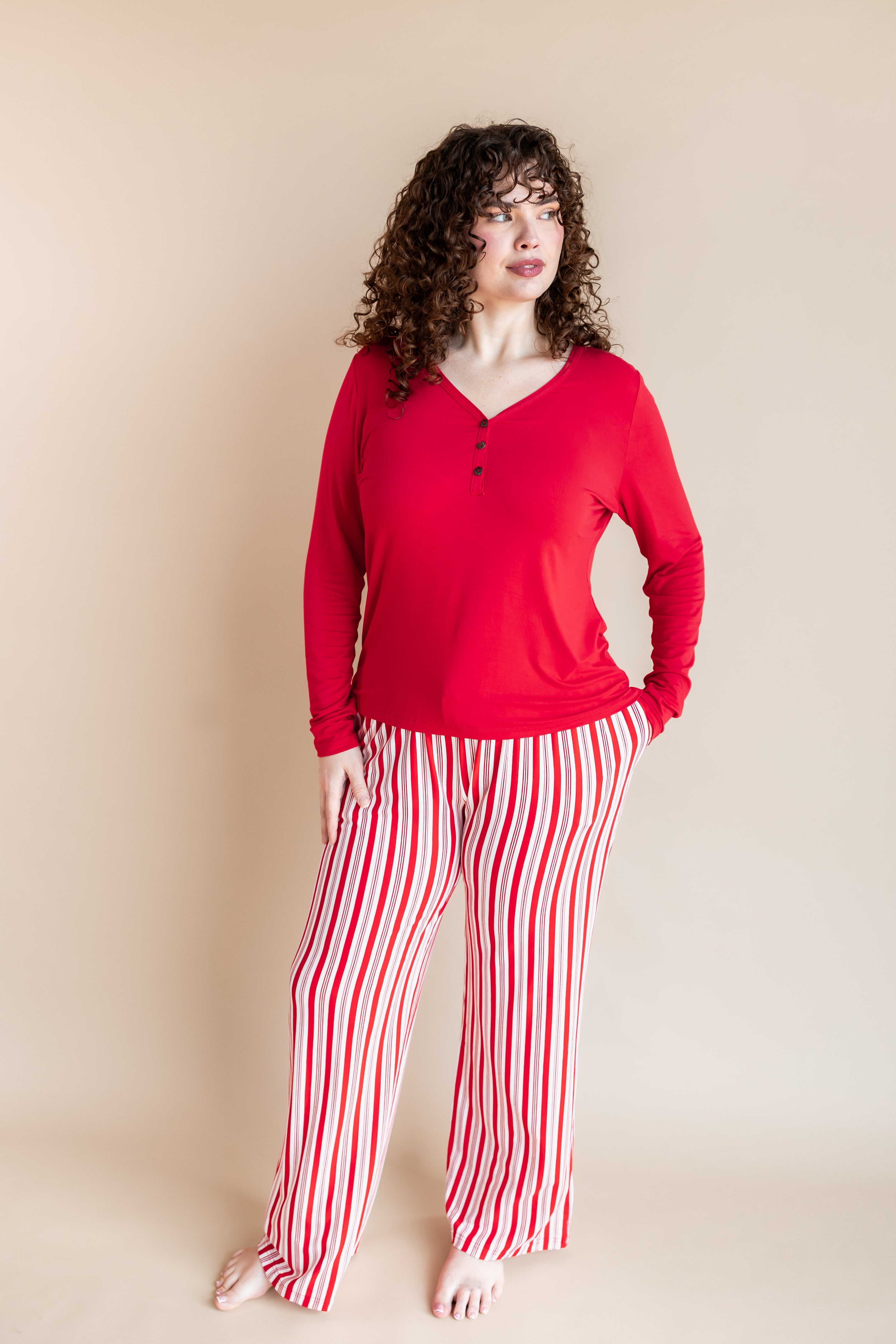 Modal wearing Women's Lounge Pants in red and white Peppermint Stripes print under a red T-shirt on a beige background
::: Model is 5'10" wearing size XL ///