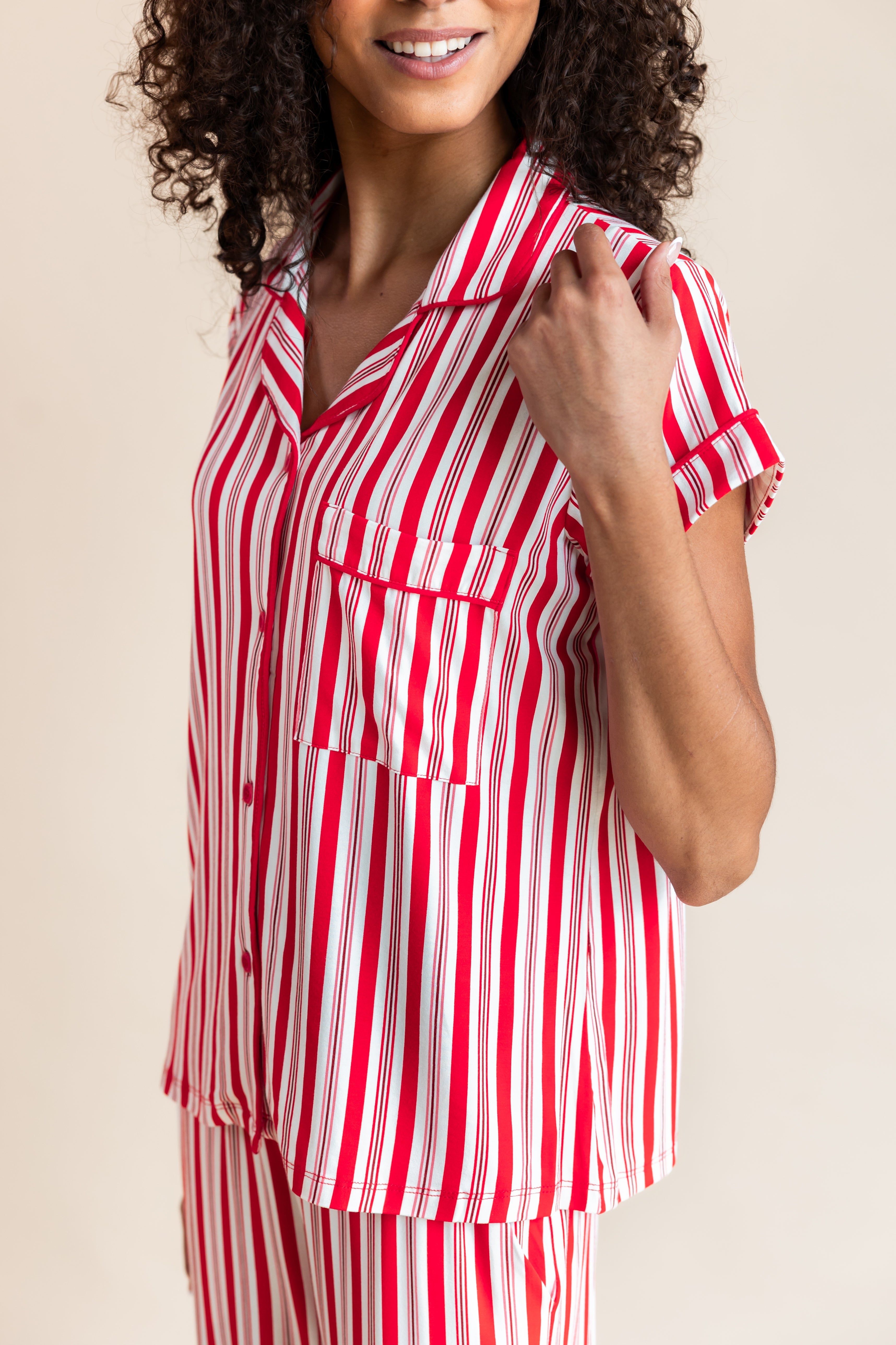 Close up of Modal wearing Women's Short Sleeve Cropped Pajama Set in red and white Peppermint Stripes print on a beige background
---PJ 2