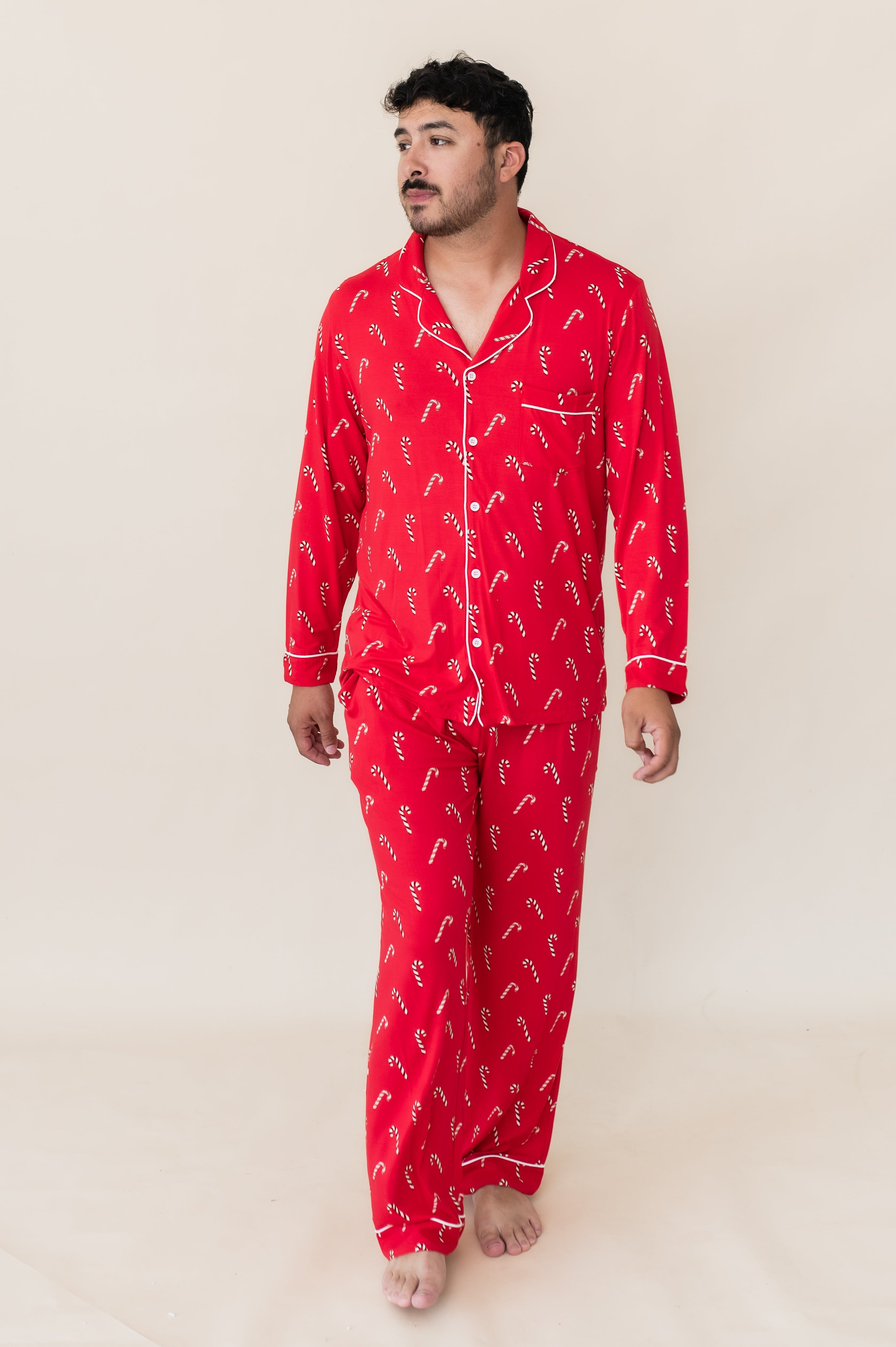 Model in front of a beige background wearing the Men's Long Sleeve Pajama Set in Candy Cane