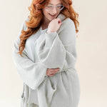 Female wearing the Chunky Knit Women's Oversized Cardigan in Oat paired with a white shirt and white pants