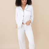 Model wearing Women's Long Sleeve Pajama Set in Snow with Midnight Trim with bottom button undone