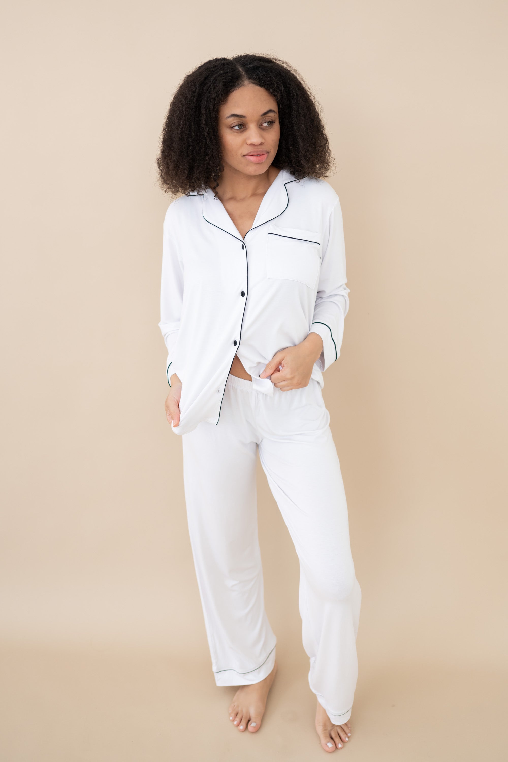 Model wearing Women's Long Sleeve Pajama Set in Snow with Midnight Trim with bottom button undone