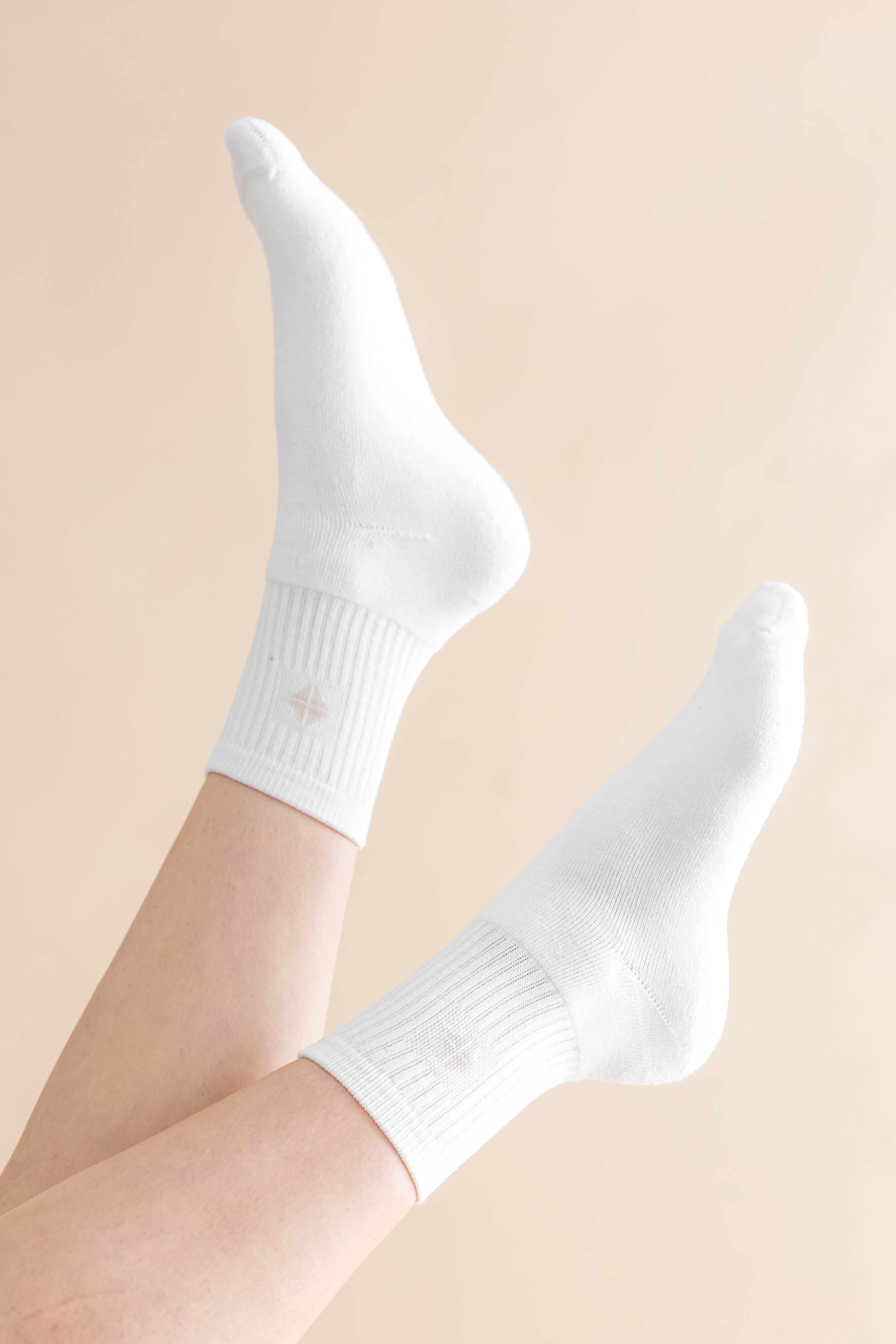 White socks worn on a beige background