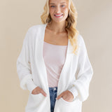 Female standing wearing the Chunky Knit Women's Oversized Cardigan in Cloud with both hands in the pocket