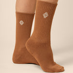 Brown socks with a white geometric design on a beige background