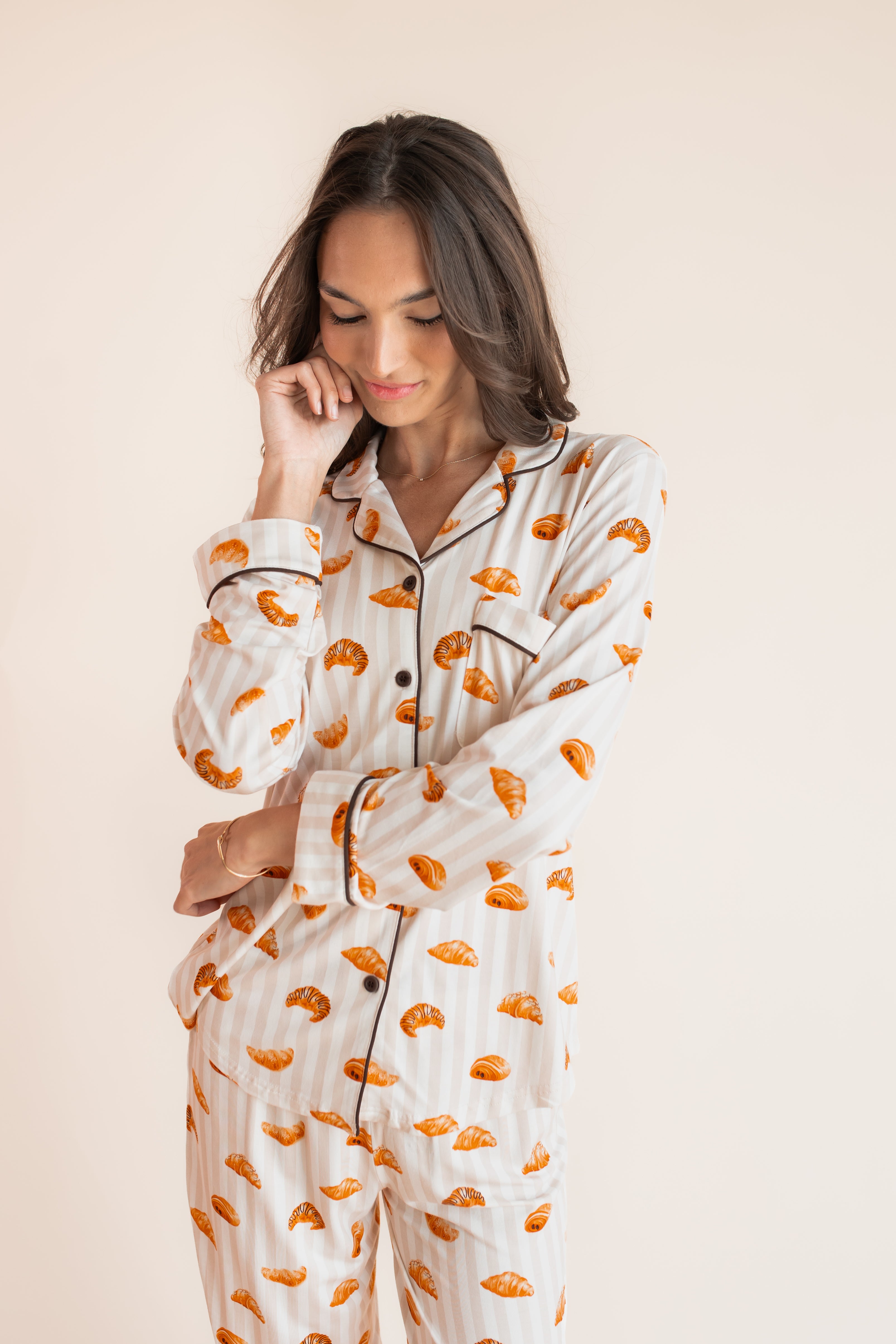 Model posing in Long-Sleeved Women's Pajama Set in Croissant print on a beige background