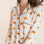 Close up of Model wearing Long-Sleeved Women's Pajama Set in Croissant print on a beige background
---PJ 2