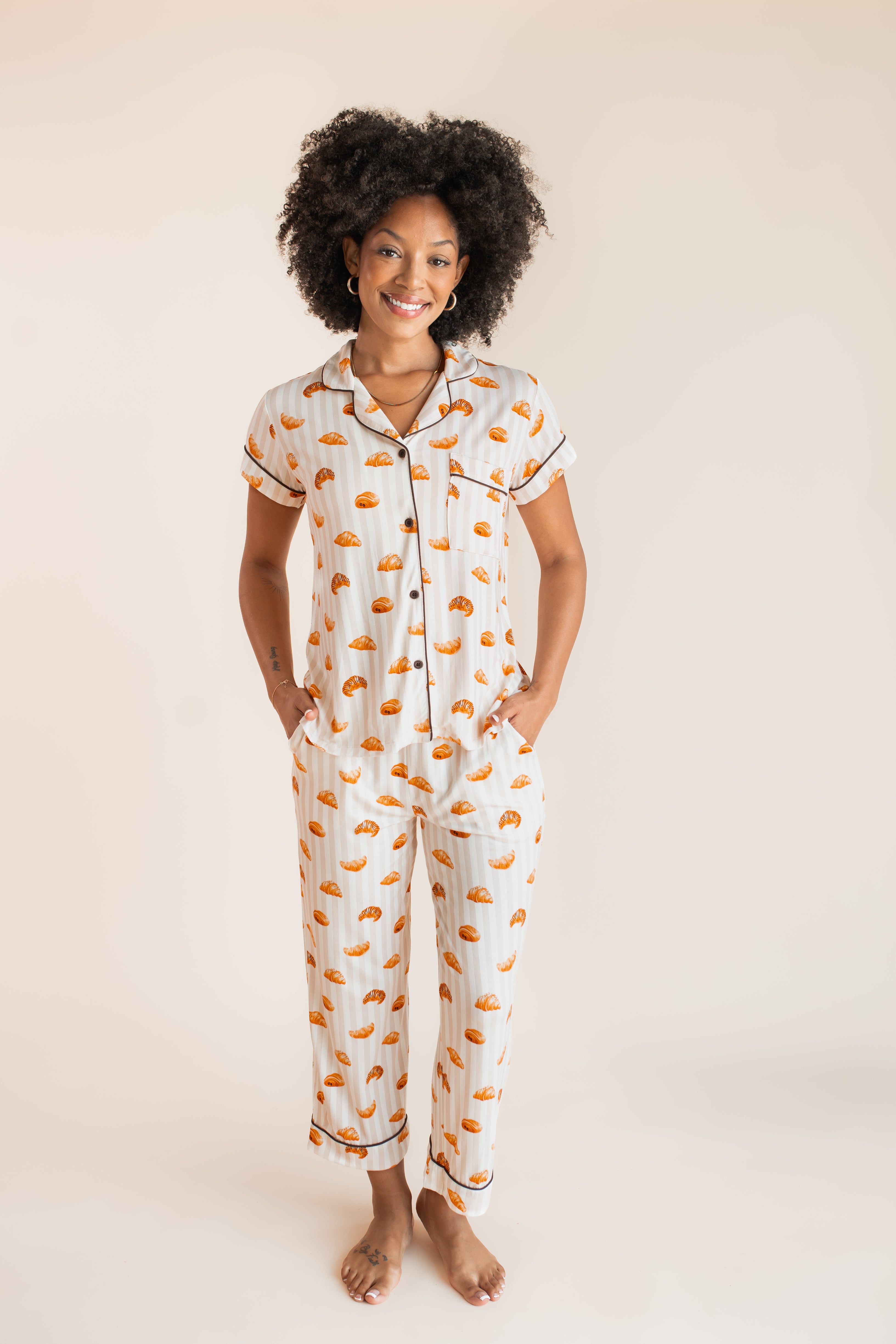 Model wearing Women's Short Sleeve Cropped Pajama Set in Croissant print on a beige background
::: Model is 5'9"" wearing size S ///
