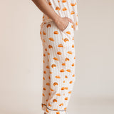 Model showcasing the pockets on Women's Short Sleeve Cropped Pajama Set in Croissant print on a beige background
---1620 3