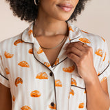 Model showcasing the collar on Women's Short Sleeve Cropped Pajama Set in Croissant print with brown trim on a beige background
---PJ 2