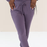 Woman modeling Women's Ribbed Jogger Pant in Currant with feet crossed in front 
