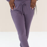 Woman modeling Women's Ribbed Jogger Pant in Currant with feet crossed in front 
