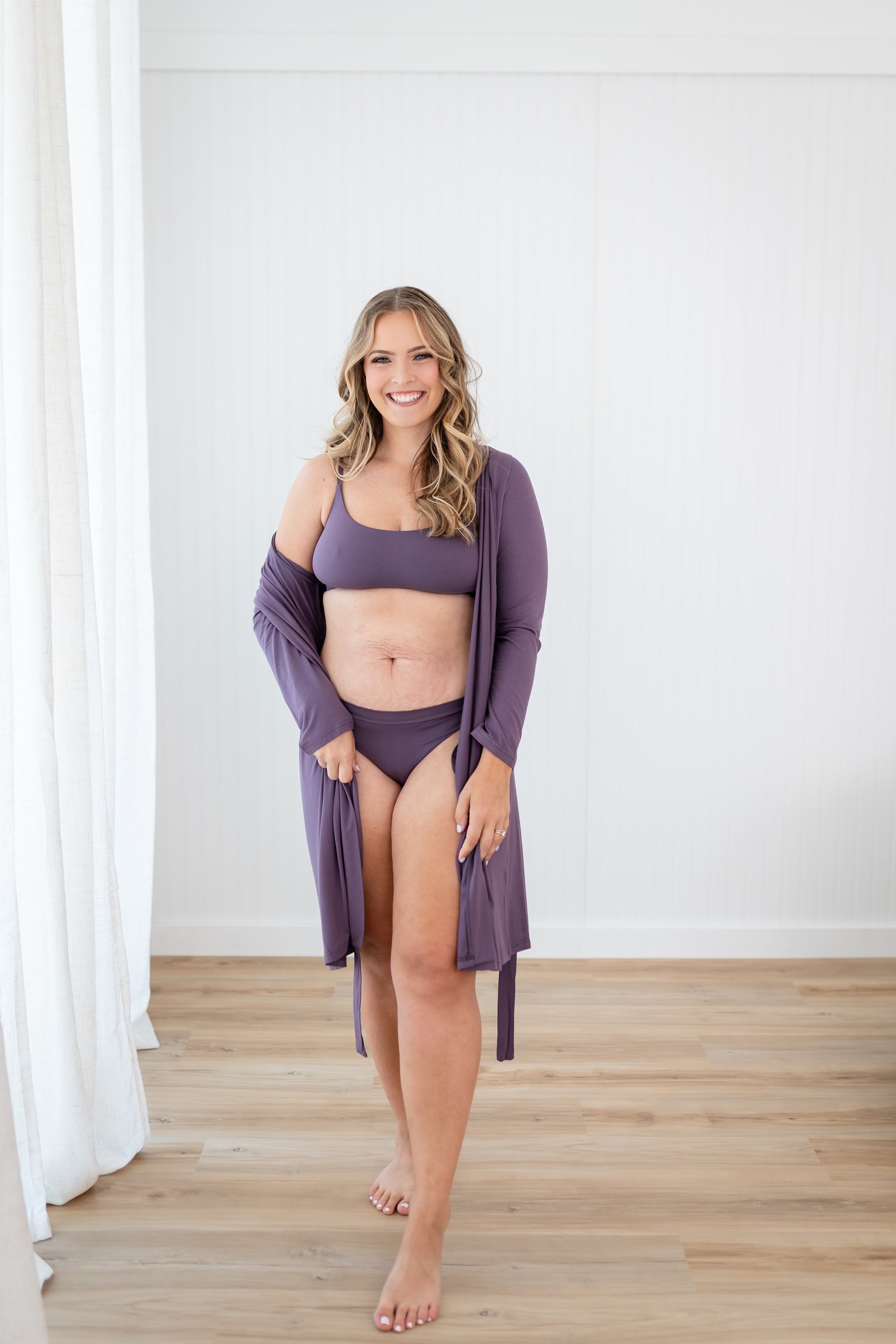 Woman in Scoop Neck Bralette in Currant and matching underwear and lounge robe