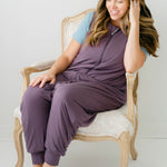Female model sitting on a chair wearing the Adult Sleep Bag Walker in Currant