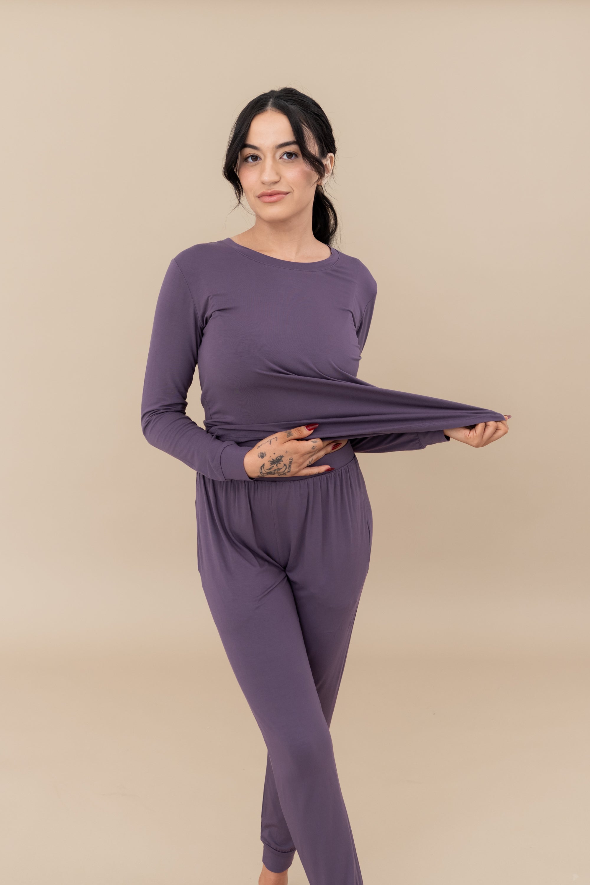 Model stretching the jogger top to show the elasticity of the fabric in the Women's Jogger Pajama Set in Currant