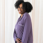Female modeling Kyte Baby's Women's Long Sleeve Pajama Set in Currant with Cloud Trim