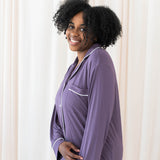 Female modeling Kyte Baby's Women's Long Sleeve Pajama Set in Currant with Cloud Trim
