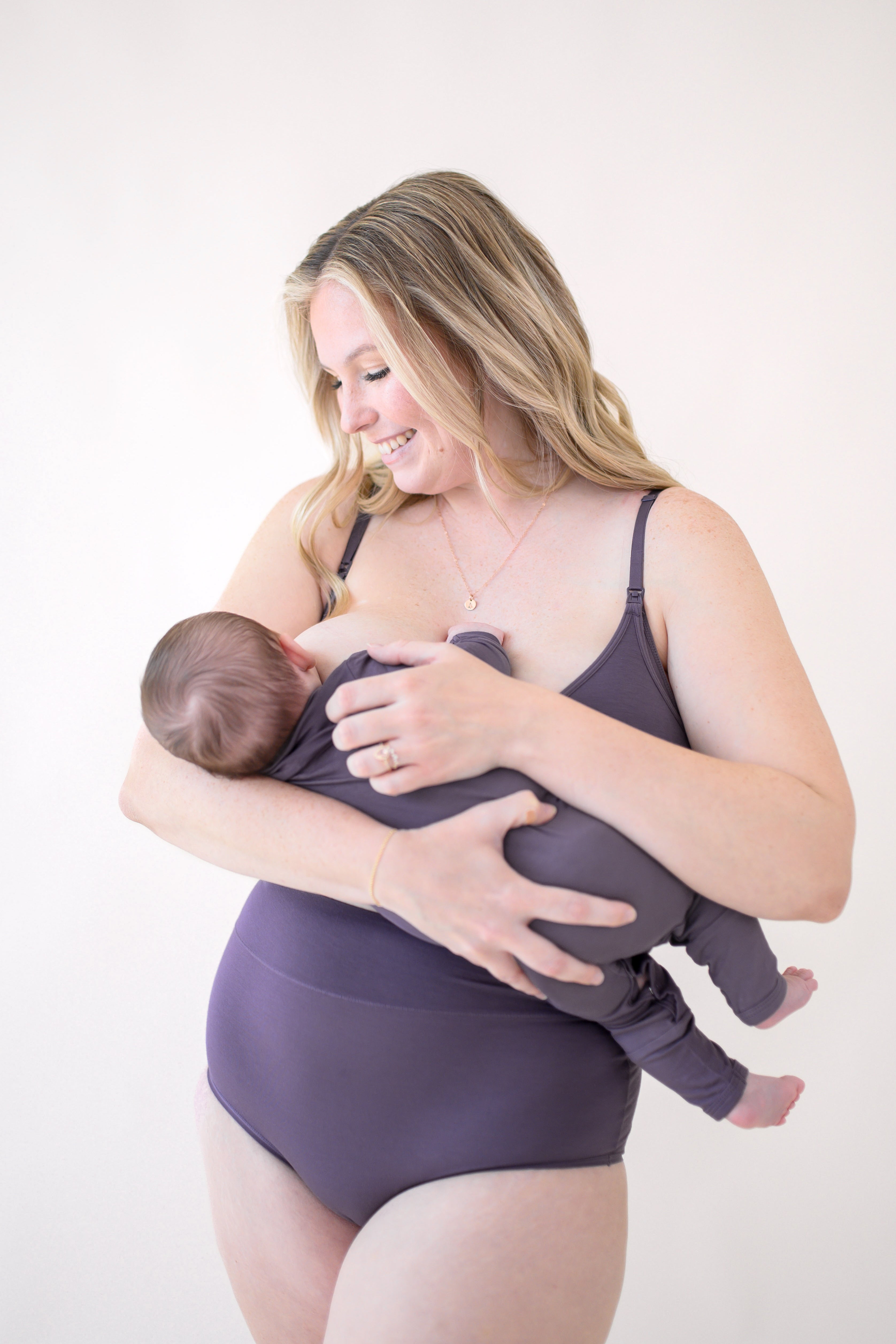 Woman nursing baby in Women's Nursing Bra in Currant and High-Waisted Brief