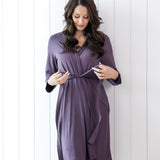 Woman wearing a purple robe against a white wooden panel background