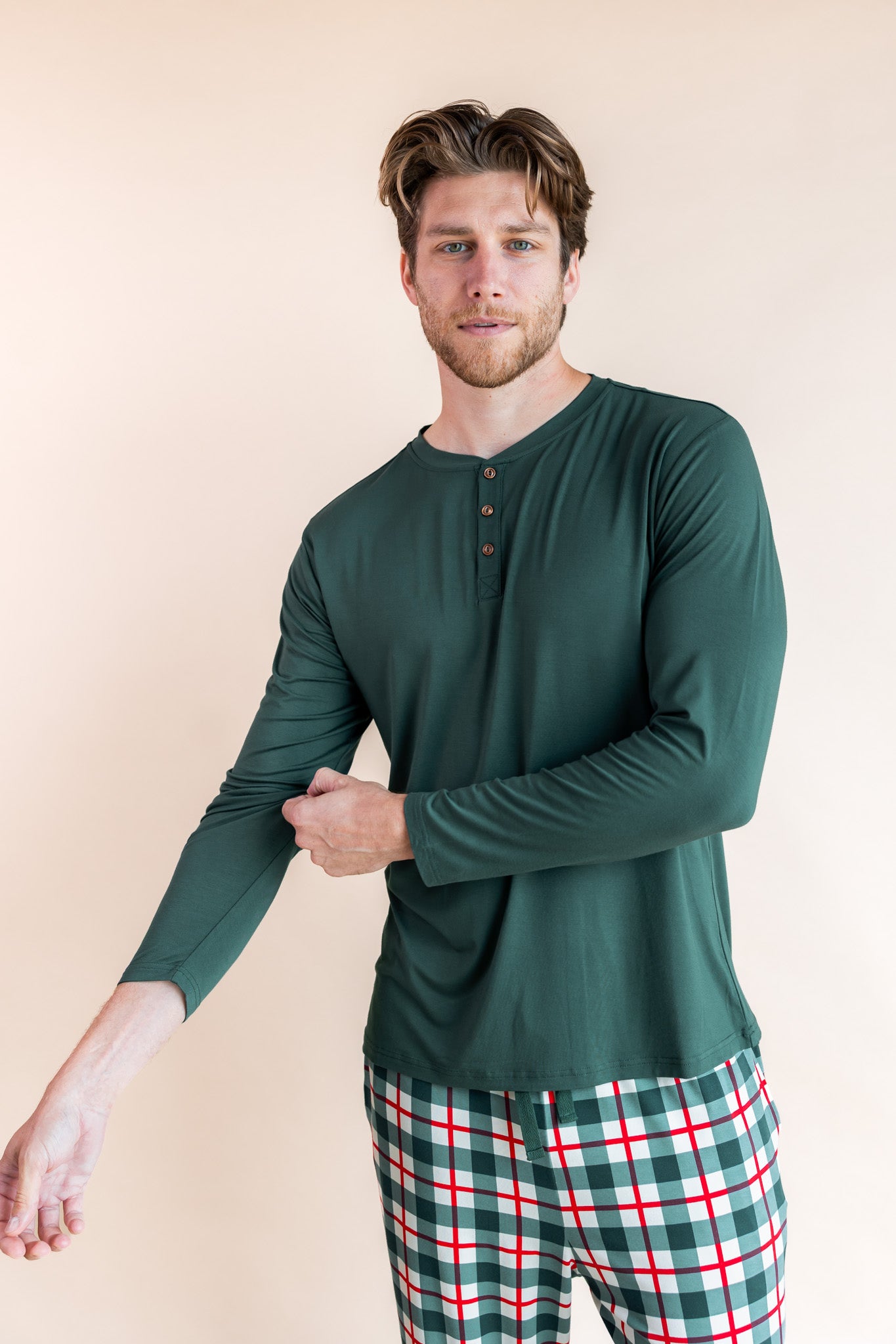 Man pulling up his sleeve wearing a Henley shirt in cypress and pants in holiday plaid
::: Model is 6'3" wearing size L ///