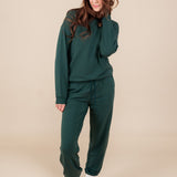 Modal posing in Women's Jogger Pant in Cypress color under similar color sweatshirt on a beige background