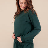 Modal posing in Women's Jogger Pant in Cypress color under similar color sweatshirt on a beige background
