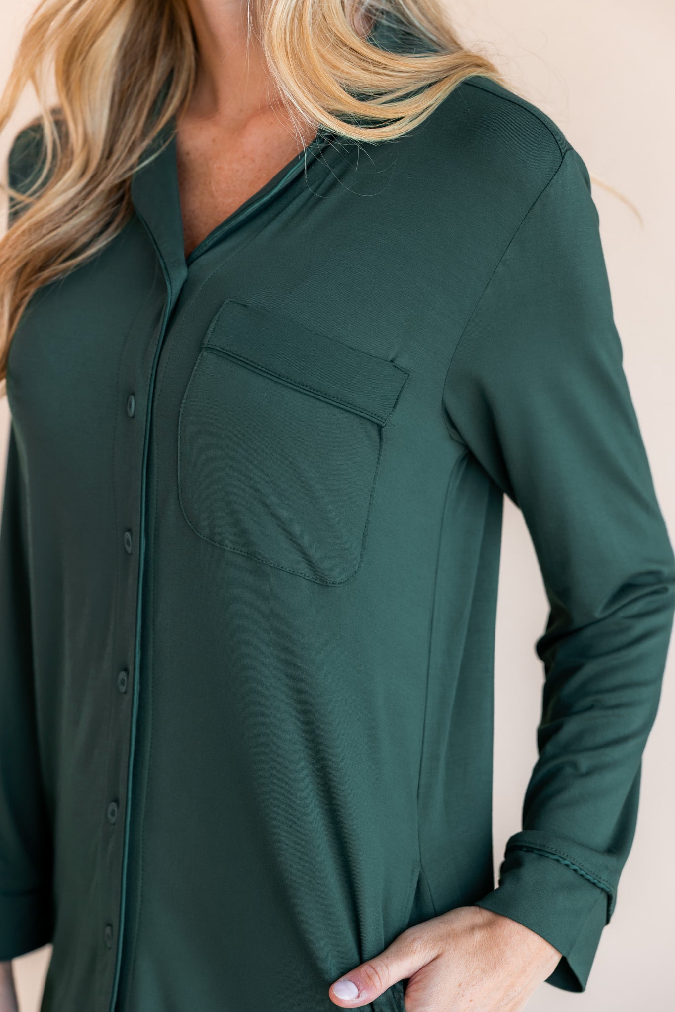 top half of a woman with her hand in her pocket wearing long sle4eve sleep shirt in cypress