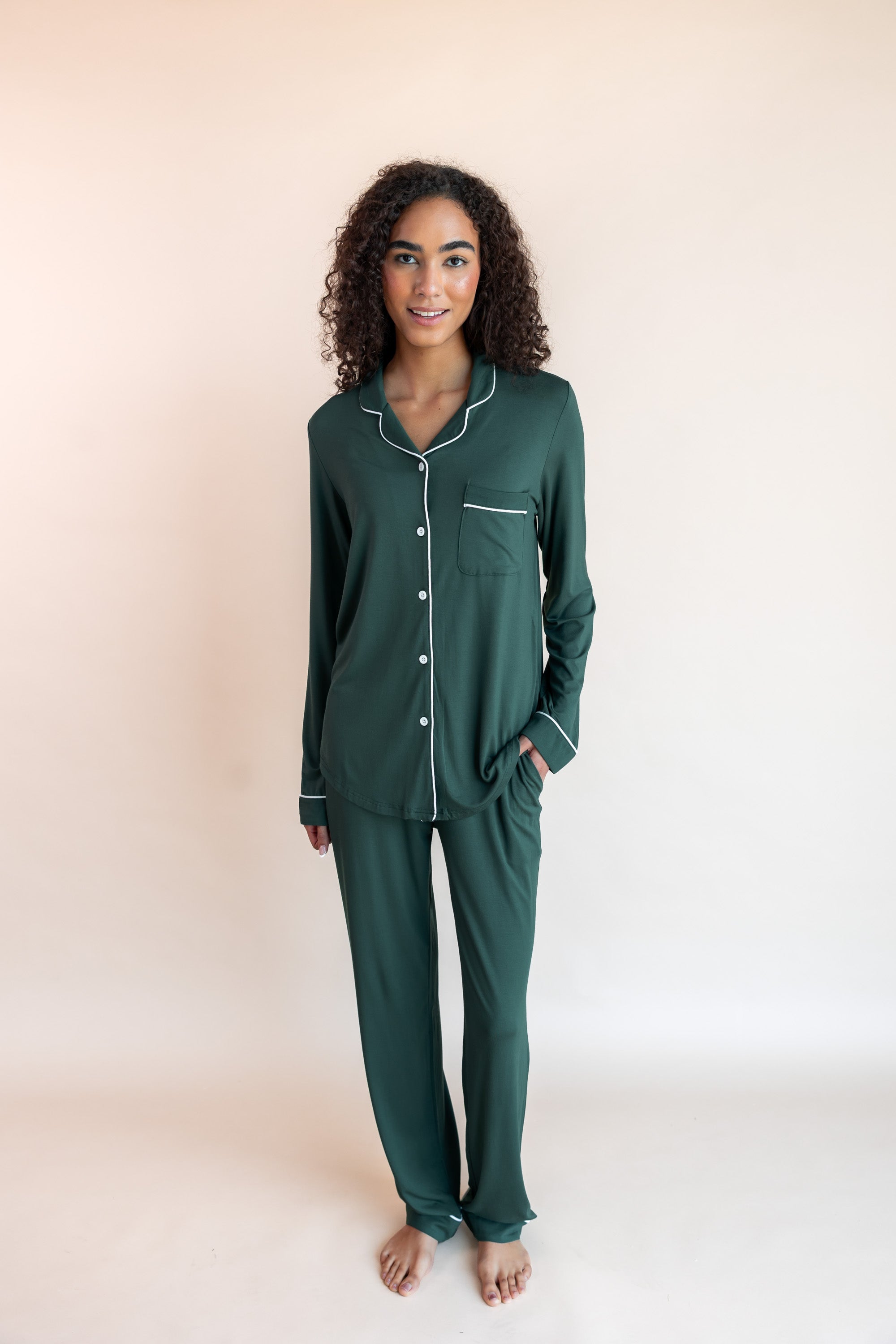 Woman standing with one hand in her pocket wearing long sleeve pajama set in cypress

