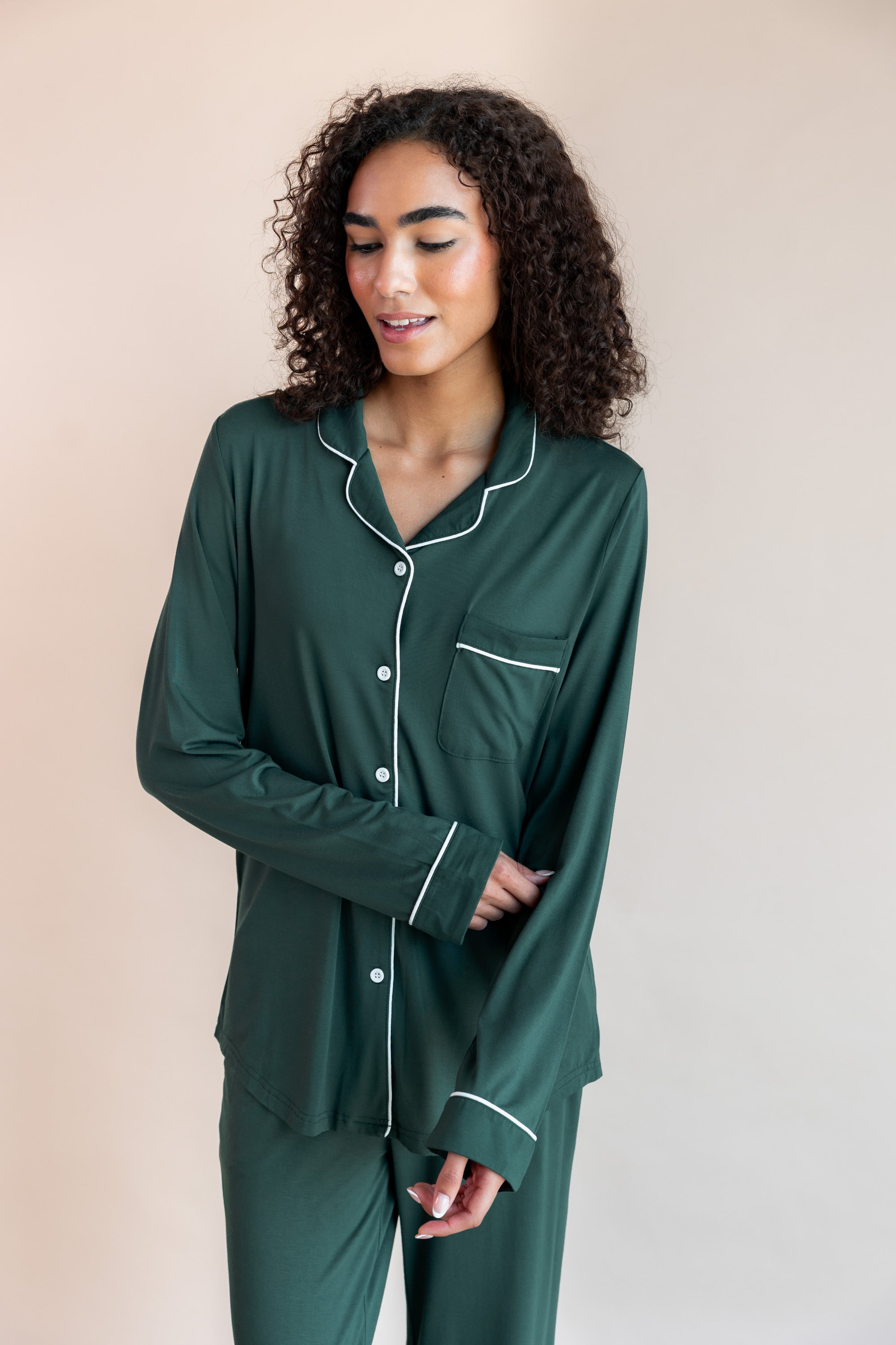 Woman pulling up her sleeve looking down wearing long sleeve pajama set in cypress

---PJ 4